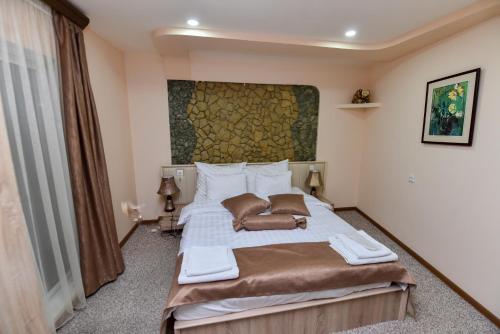a bedroom with a bed with a large painting on the wall at Gayane Hotel in Alaverdi