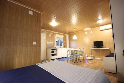 a bedroom with a bed and a kitchen with a table at Burriscas Campismo Rural in Montemor-o-Novo