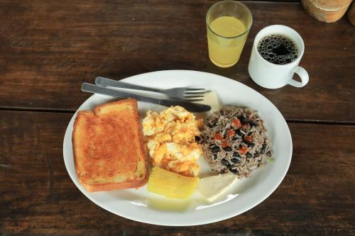 a plate of breakfast food with eggs toast and beans at La Tigra Rainforest Lodge in Fortuna