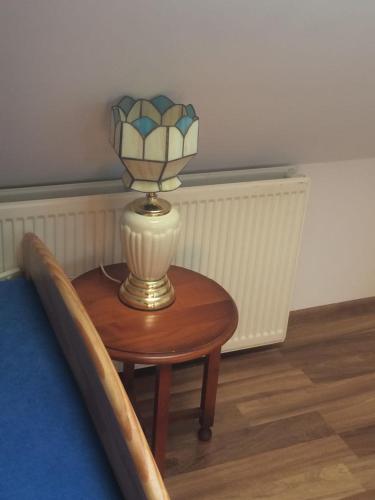 a small table with a lamp on top of it at UDany Wypoczynek in Wojanów