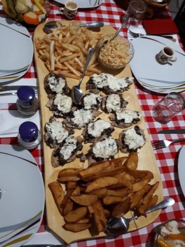 a table with a tray of food with french fries at Lörincz Vendégház in Corund