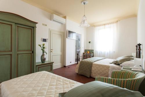 a hotel room with two beds and a window at Il Portico Camere e Caffè - centro Città in Savignano sul Rubicone