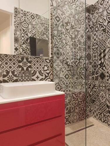 a bathroom with a red sink and a mirror at casa azzurra in San Foca