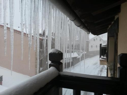 a window covered in snow with icicles at Artesano II in Navarredonda de Gredos