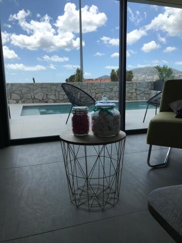 a table with two jars on it next to a pool at Villa d'exception, piscine, vue mer, plage à 100M in Ajaccio