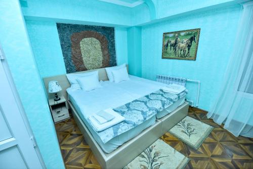 a bedroom with a bed in a blue room at Gayane Hotel in Alaverdi