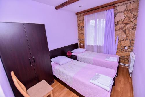 a small bedroom with two beds and a cabinet at Gayane Hotel in Alaverdi