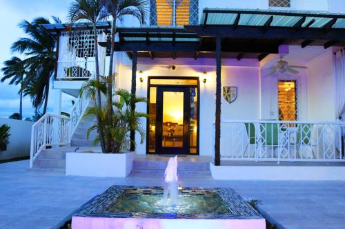a house with a fountain in front of a building at Villa Boscardi in Belize City