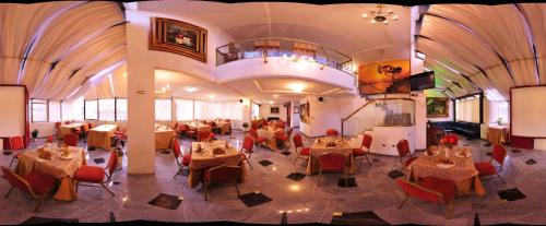 a dining room with tables and chairs in a building at Hotel Cordero in Cuenca