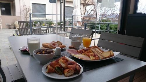 a table with two plates of breakfast foods and drinks at Ellopia Point Hotel in Ioannina