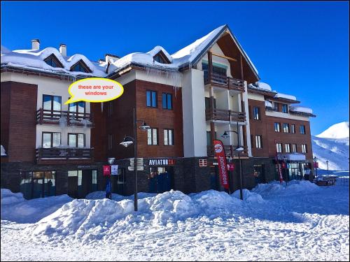 a large building with a sign in the snow at Zen Apartments Gudauri in Gudauri