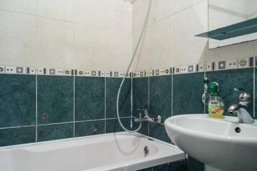 a bathroom with a sink and a bath tub next to a sink at Apartments on Bolshaya Morskaya 65 in Mykolaiv