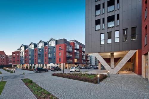 una calle de la ciudad con edificios altos y un aparcamiento en Holidays Home Apartamenty Chmielna, en Gdansk