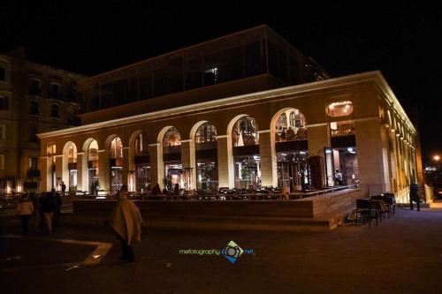 a large building with people walking in front of it at night at Valletta Harbour View Apartment in Valletta