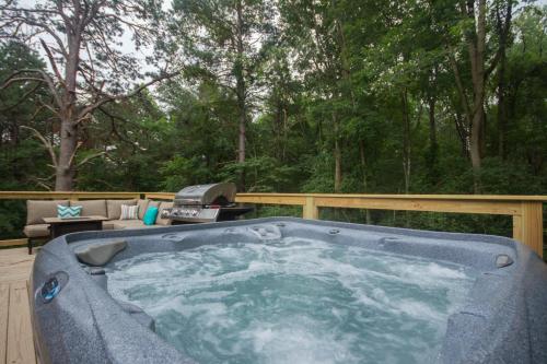 a hot tub on a deck with a grill at Heaven's Hideaway- perfect getaway near the river! in Luray