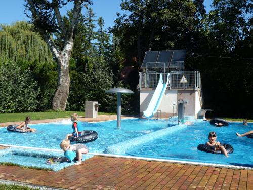 eine Gruppe von Kindern, die im Pool spielen in der Unterkunft SunVillage Camp- Mobilházak Alsóörsön in Alsóörs