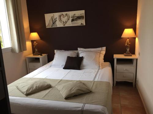 a bedroom with a large white bed with two night stands at La maison de Virginie 6 a 12 personnes -300 m de la plage- vélos a disposition in Saint Cyprien Plage