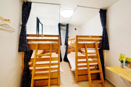 a room with two bunk beds and two stools at add-Hostel Uji Cha-gan-ju-tei in Uji
