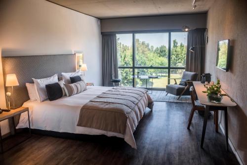 una camera d'albergo con un grande letto e una scrivania di KOS Pilar Hotel a Pilar