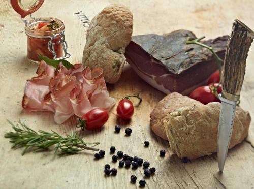 a table topped with bread and meat and vegetables at Hotel Gallia in Stelvio
