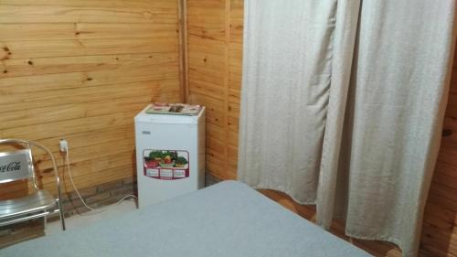 a room with a small refrigerator and a curtain at Gaboto, solo se reserva con sena , entrar en contacto in Chuy