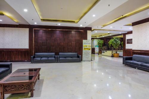 a lobby with couches and a table in a building at Orchardz Jayakarta in Jakarta