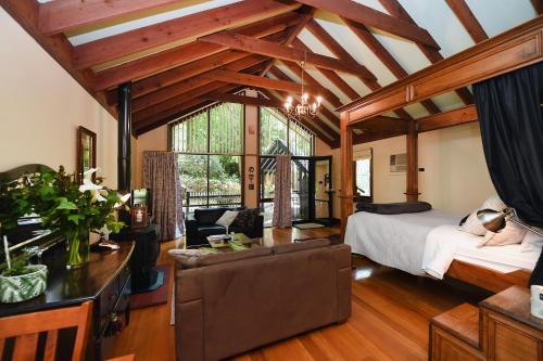 um quarto com uma cama e um sofá num quarto em Cambridge Cottages em Olinda