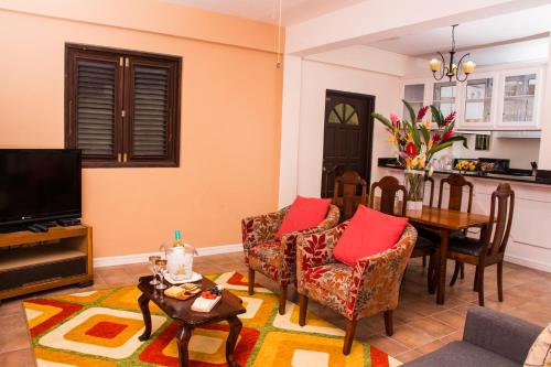 a living room with a table and chairs and a television at Heavenly Suites in La Feuillet