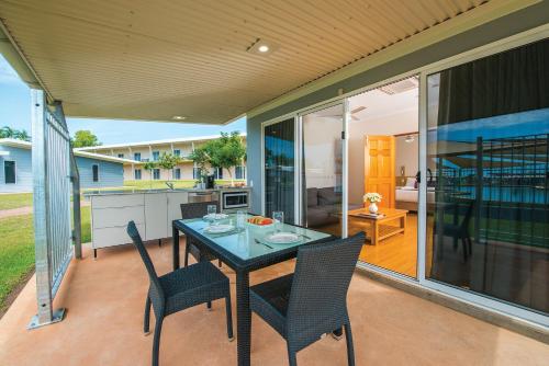 a patio with a table and chairs and a kitchen at Club Tropical Resort Darwin in Darwin