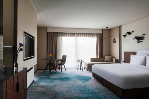 a hotel room with a bed and a living room at Pullman Zhouzhuang in Kunshan