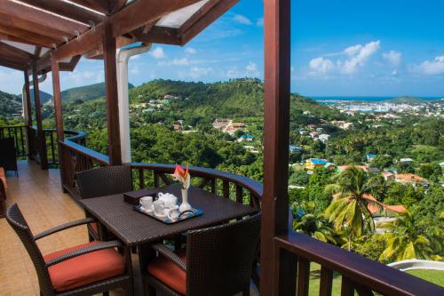 a balcony with a table with a view of the ocean at Heavenly Suites in La Feuillet