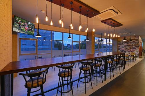 a long bar with stools in a restaurant at POP! Hotel Banjarmasin in Banjarmasin