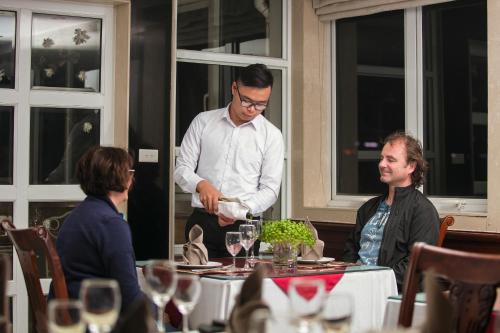 a man is standing at a table with a woman at Hanoi Emotion Hotel in Hanoi