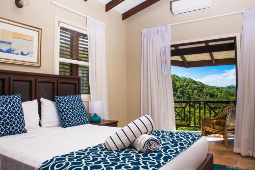a bedroom with two beds and a balcony at Heavenly Suites in La Feuillet