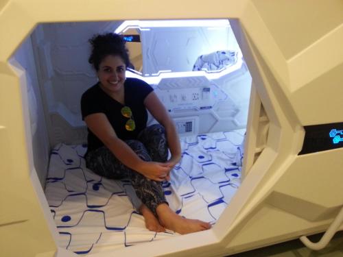 a woman is sitting in an open refrigerator at Space Cap Hotel in Kota Kinabalu