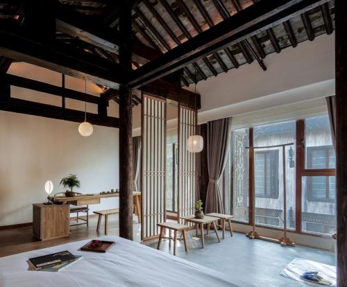 a bedroom with a bed and a table and chairs at Uin Oriental Hotel in Wuxi