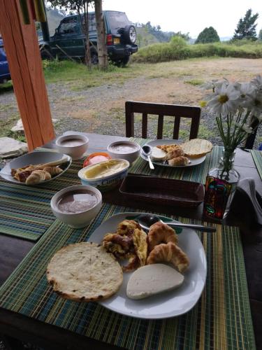 a table with a plate of food on it at Tarragona Hostal in Santa Rosa de Cabal
