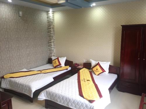 two beds in a small room withskirts at Minh Kieu Hotel in My Tho
