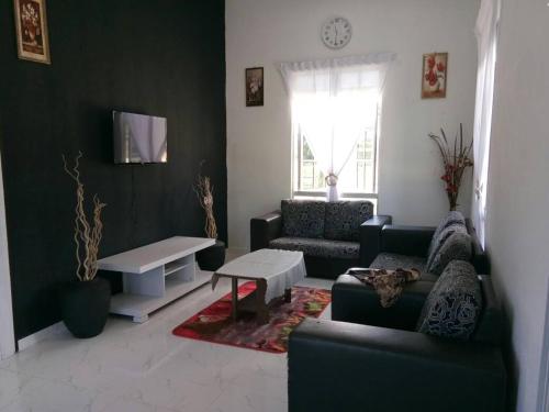 a living room with a couch and a table at Penarik baru homestay in Penarek