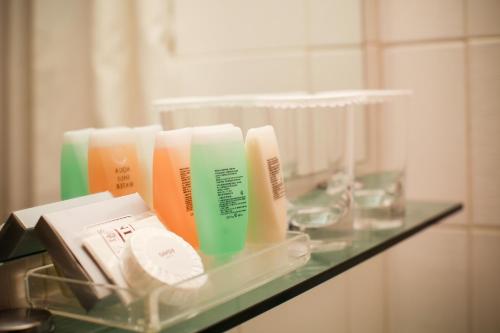 a glass shelf with different colored hair products on it at Savoy Hotel Myeongdong in Seoul