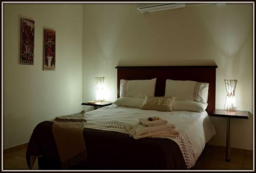 a bedroom with a large bed with two lamps at Coffee@Home (Pty) Ltd in Prieska