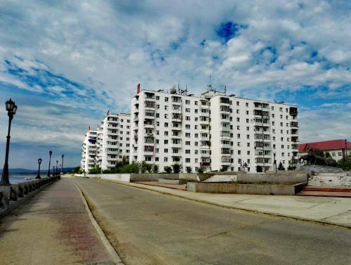 レンスクにあるApartments on Naberezhnaya 2の道路脇の白い大きな建物