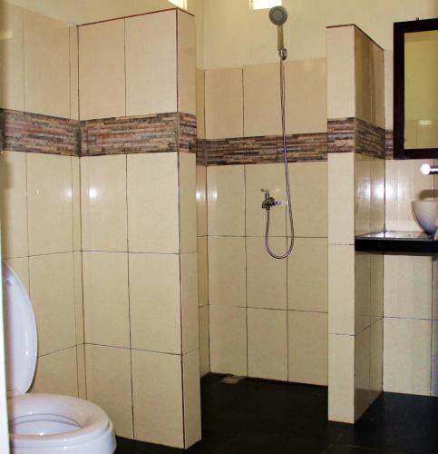 a bathroom with a shower and a toilet at Happy Gecko Dive Resort in Bunaken