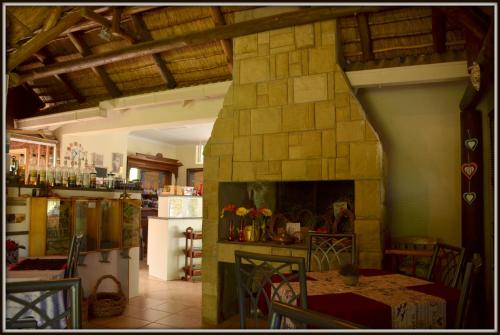 ein Wohnzimmer mit einem Steinkamin und einem Tisch in der Unterkunft Coffee@Home (Pty) Ltd in Prieska
