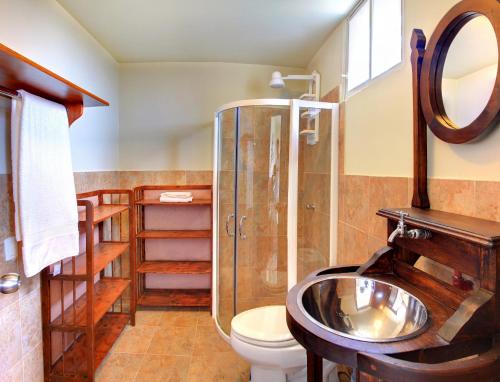 a bathroom with a shower and a sink and a toilet at Saint Patricks Lodge in Santa Elena
