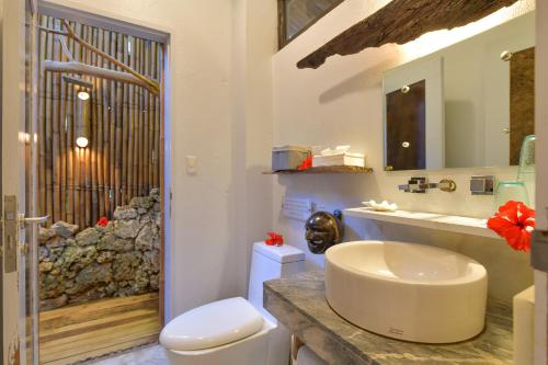 a bathroom with a toilet and a sink and a mirror at Diniview Villa Resort in Boracay