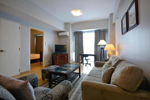 a living room with a couch and a table at Avant Serviced Suites - Personal Concierge in Manila