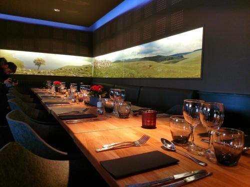 a long table in a restaurant with glasses and napkins at Logis Hôtel et Spa Chez Camillou in Aumont-Aubrac