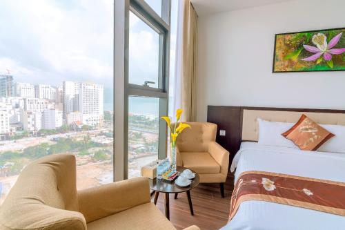 a hotel room with a bed and a chair and a window at Dana Marina Boutique Hotel in Da Nang