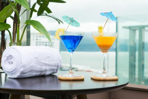two cocktails sitting on a table with towels and towels at Dana Marina Boutique Hotel in Da Nang
